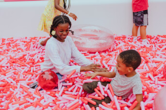 Guests playing in MUSEUM OF ICE CREAM's outdoor sprinkle pool for NICD