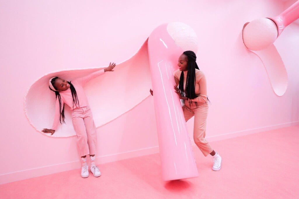 Picture - A mom and daughter playing with the big ice cream scoops on a wall.