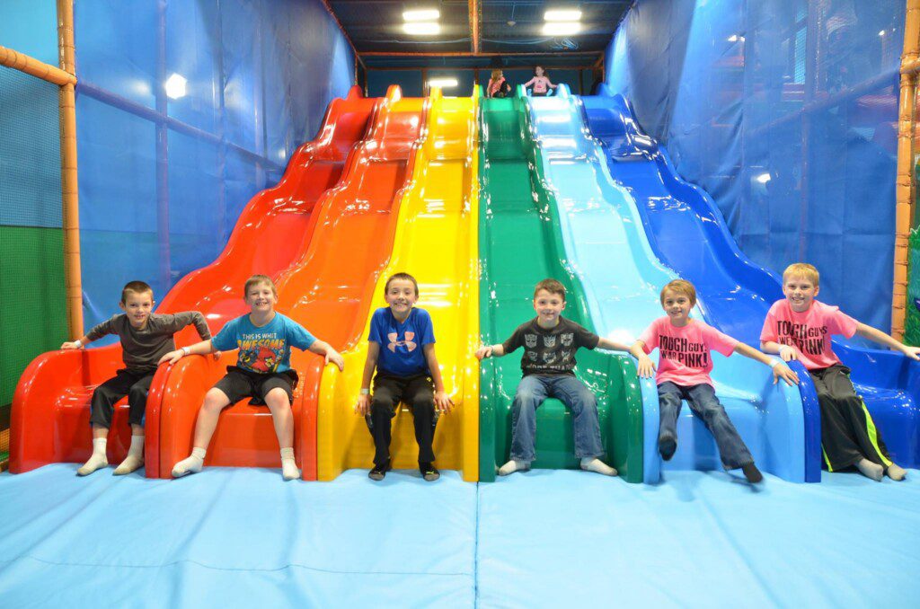 Kids posing on rainbow slides at Billy Beez