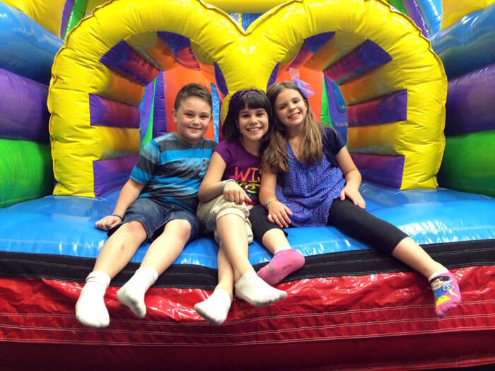 Kids sitting in a bounce house at Bounce N Play