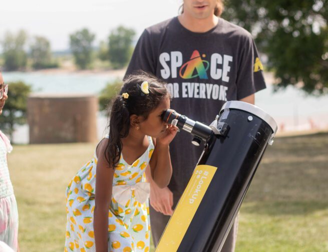 Child looking through a telescope at Adler Planetarium in Chicago