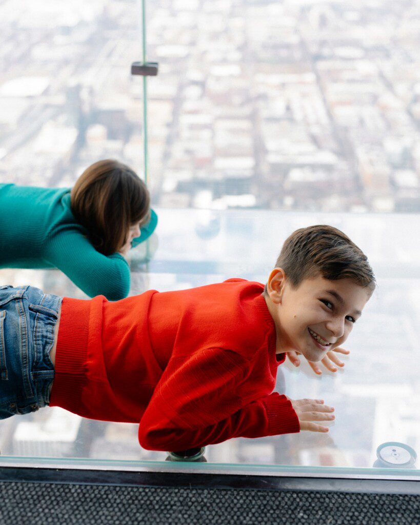 Kids looking through the glass ledge at Skydeck Chicago.