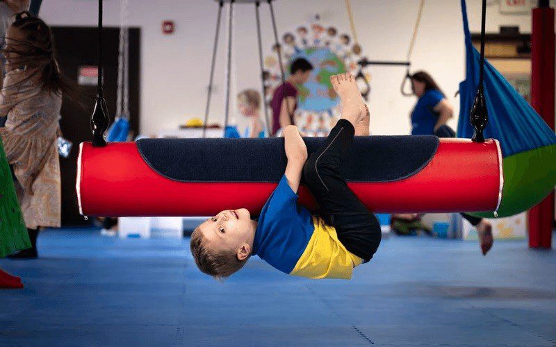 Child playing on gym equipment at We Rock The Spectrum