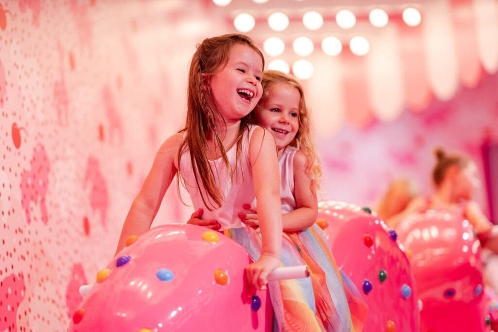 Kids playing on pink ice cream sculptures at Museum of Ice Cream NYC