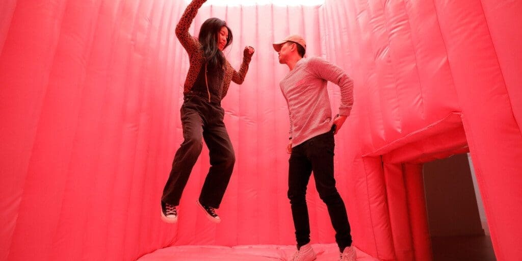 a couple jumping at Museum of Ice Cream Chicago