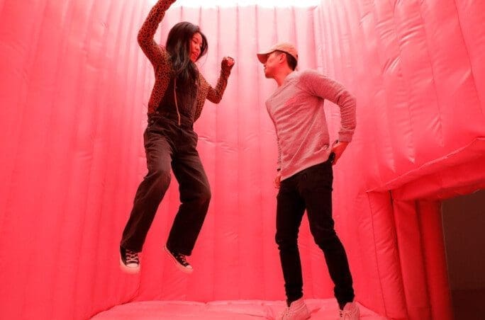 Couple jumping in a red room at Museum of Ice Cream