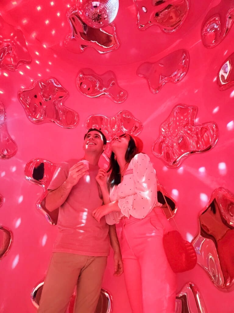 Couple enjoying a playful pink room at Museum of Ice Cream
